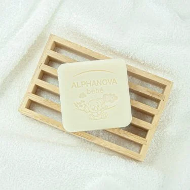 Photo du gel lavant solide bébé surgras ALPHANOVA bébé bio ® sur un porte savon.