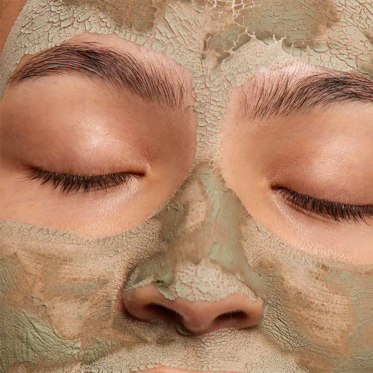 Femme avec un masque purifiant anti-imperfections bio à l’argile et au zinc appliqué sur le visage